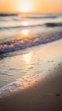 Peaceful beach sunset with soft ocean waves gently washing ashore and warm glowing sunlight reflection
