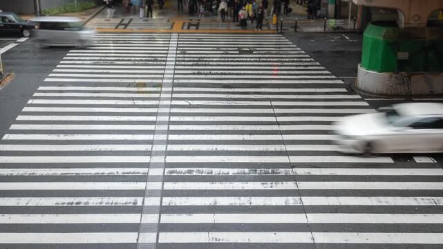 Pedestrians crossing the street on a rainy day in Osaka, Japan, city life, business and finance concept.