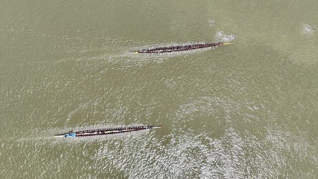Aerial view of traditional long racing boats with many rowers navigating the river in Sirajganj, Rajshahi Division, Bangladesh.