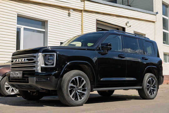 Black modern Haval H9 SUV car with protective polyurethane paint protection film PPF wrapped on body bodywork parked on an urban street near building facade, exterior view of premium chinese SUV car. 