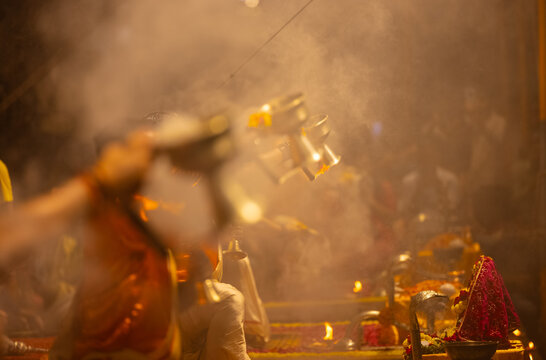 Portrait of unidentified Hindu priests performs the sacred evening Ganga Aarti ceremony at Assi Ghat in Varanasi. Dressed in traditional attire, the priests conduct the ritual with lamps.