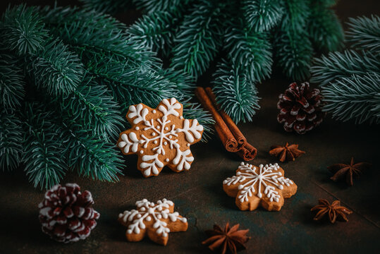 Gingerbread snowflakes and Christmas decorations on a dark rustic background, selective focus
