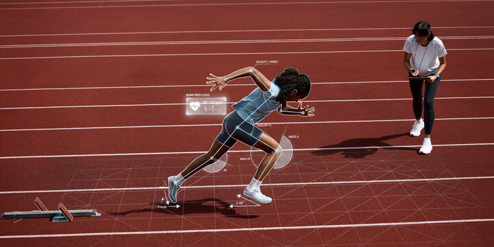 Female sprinter launching from starting blocks while coach reviews biometric and body mechanics data. Concept of smart training, coaching assessment and sprint development.