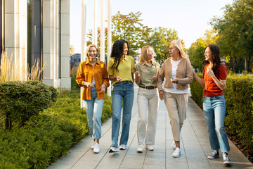 Fototapeta premium Diverse women friends walking and talking together outdoors