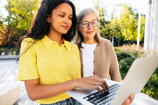 Diverse women collaborating on laptop showing mentorship
