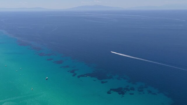 Motorboat crossing turquoise and deep blue Greek waters