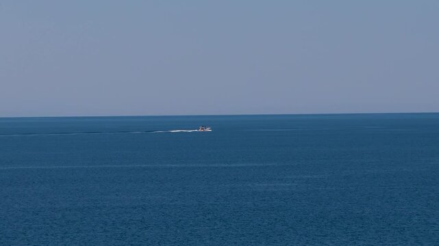 Speedboat traveling across open Greek waters beneath a clear