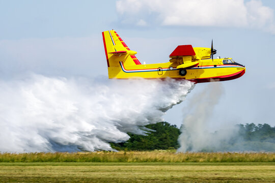Water bomber aircraft releasing water during aerial firefighting