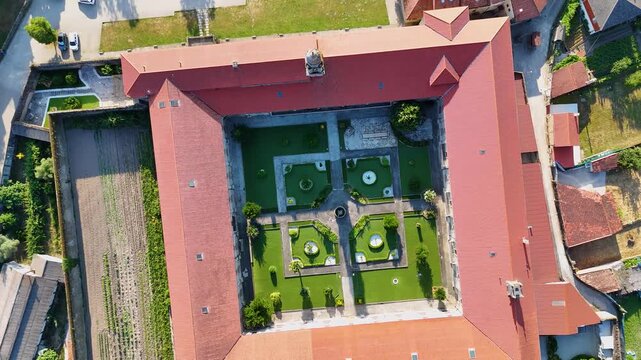 Aerial view of the historic convent courtyard in Allariz with its symmetrical garden, stone walkways, and red-tiled roof in Allariz, Province of Ourense, Spain.