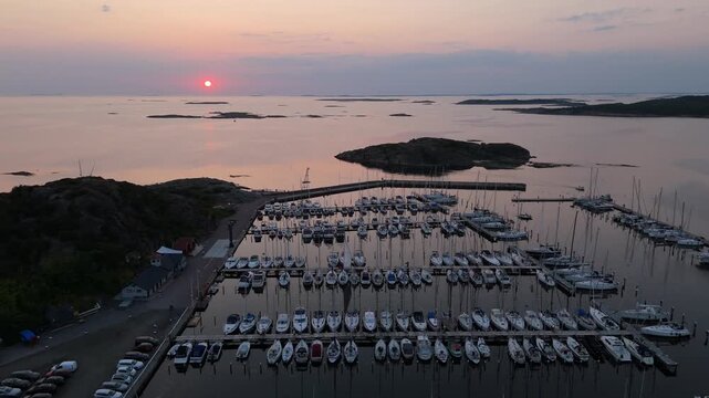 Aerial view of Sando marina with rows of docked sailboats and motorboats at sunset in Vallda, Hallands lan, Sweden.