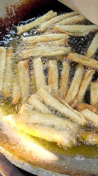 Crispy Indonesian Risol Deep Frying in Hot Oil. Golden crispy risol rolls sizzle in bubbling hot oil, capturing authentic Indonesian street food preparation. Food video 4k 60 fps.