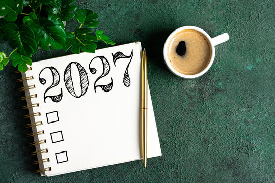 New year resolutions 2027 on desk. 2027 resolutions list with notebook, coffee cup on table. Goals, resolutions, plan, action, checklist concept. New Year 2027 template, copy space