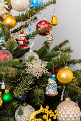 Fototapeta premium A Christmas tree stands with many colorful ornaments hanging from its branches. Each ornament shows different shapes and colors, celebrating the festive season and bringing joy to the home