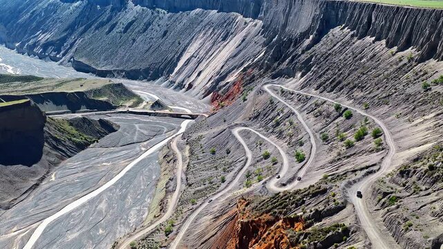 Aerial view of a winding zigzag road down a steep canyon cliff in Anjihai Grand Canyon, Xinjiang, China