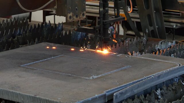 CNC torch tracing a part outline on steel plate with sparks