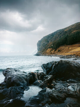 Vagsoy island in Norway moody landscape sea and rocky cliff stormy rainy weather dramatic scenery travel beautiful destinations norwegian nature autumn season