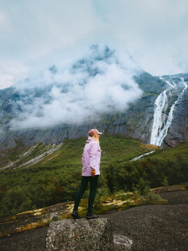 Woman hiker travel solo in Norway tourist hiking in foggy mountains enjoying waterfall and forest view, active summer vacations healthy lifestyle tour explore Stryn nature in the great outdoors