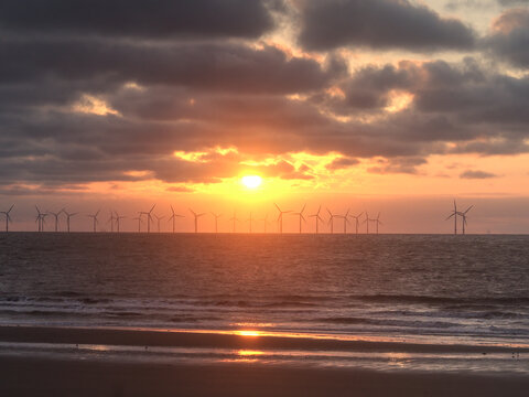 Wind generators in the distance off the north-west coast of England at sunset.