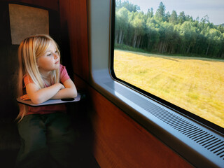 Fototapeta premium Child girl travel by train kid passenger looking at window and thinking enjoying nature view summer family vacations lifestyle, people using railway public transport