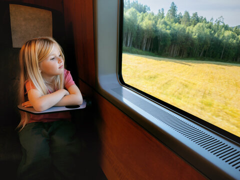 Child girl travel by train kid passenger looking at window and thinking enjoying nature view summer family vacations lifestyle, people using railway public transport