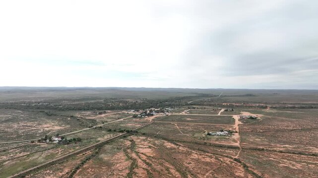 High aerial drone view over the tiny remote settlement of Silverton surrounded by an immense expanse of Australian outback near Broken Hill, New South Wales.