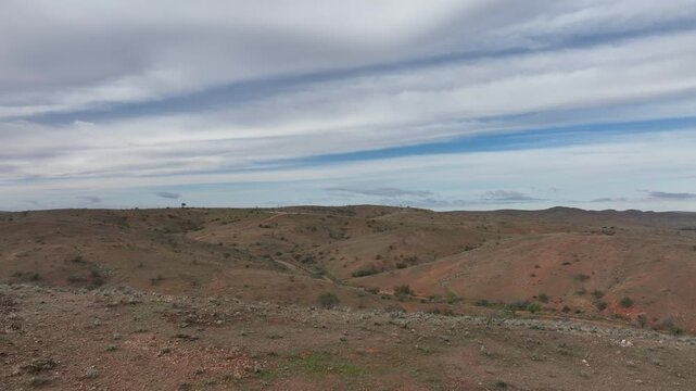 Low aerial drone flight across rugged rolling hills in the remote semi-arid landscape surrounding Silverton near Broken Hill, New South Wales.