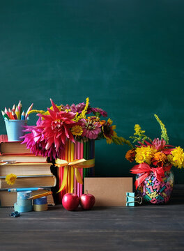 Education, back to school, beginning of the school year, Teacher's day, Knowledge Day, 1 September concept. Stack of learning books, school stationery, apples, flowers bouquet on table. copy space