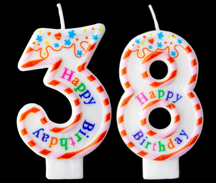 Number thirty eight shaped birthday candle with colorful sprinkles and Happy Birthday text isolated on a black background
