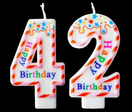 Number forty two shaped birthday candle with colorful sprinkles and Happy Birthday text isolated on a black background
