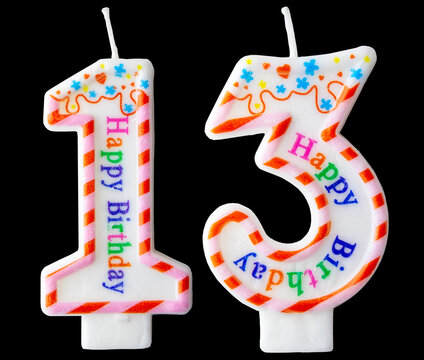 Number thirteen shaped birthday candle with colorful sprinkles and Happy Birthday text isolated on a black background