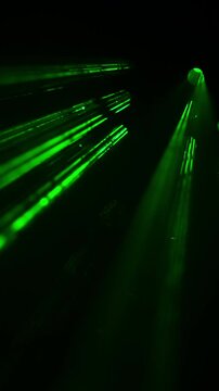 Green Light Beams Moving Through Dark Abstract Scene. Bright green luminous rays and glowing points shift across a deep black background.