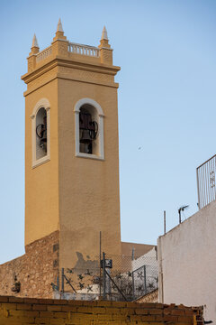 View of the historic bell tower of the Parish Church of Nuestra Senora de las Nieves rising above the rooftops in the old town of Calp, Comunidad Valenciana, Spain.