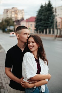 Young couple sharing tender kiss on city street