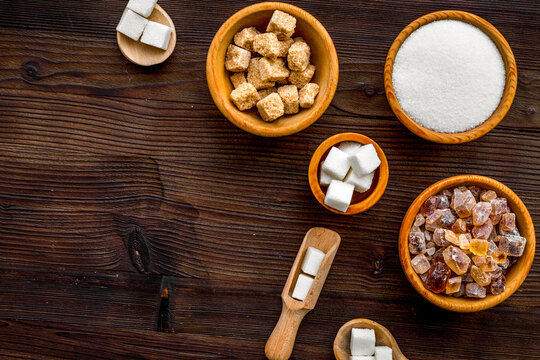 Sugar types. Cane, refind, granulated, cubes, candy sugar. Dark wooden background top view copy space