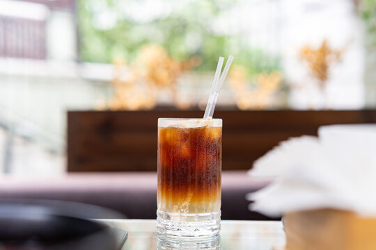 Iced espresso tonic cocktail glass on outdoor cafe table