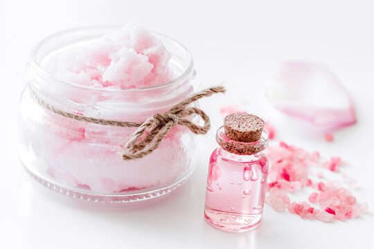 body treatment with rose petals and cosmetic set white desk background