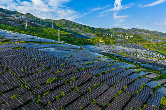 Aerial view of a large-scale solar farm with photovoltaic panels on green mountain slopes in Guizhou, China