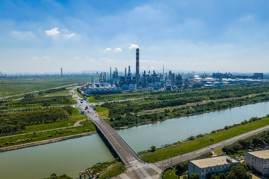 An aerial view of a large modern chemical plant and petrochemical refinery complex next to a river in China