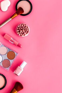 Makeup concept. Frame with decorative cosmetics and brushes on pink background top view copy space