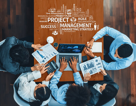 A diverse group of professionals engaged in a collaborative project management meeting, analyzing reports and strategies using technology to enhance productivity and success. Amity