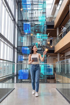 Professional walking through a corporate atrium beneath a holographic data network
