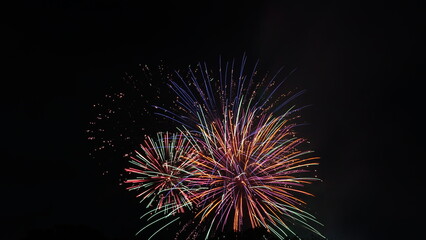 Obraz premium Vibrant Colorful Fireworks Displaying over the Night Sky during Japanese Summer Hanabi Festival