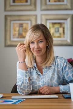 Confident blond haired woman working from home