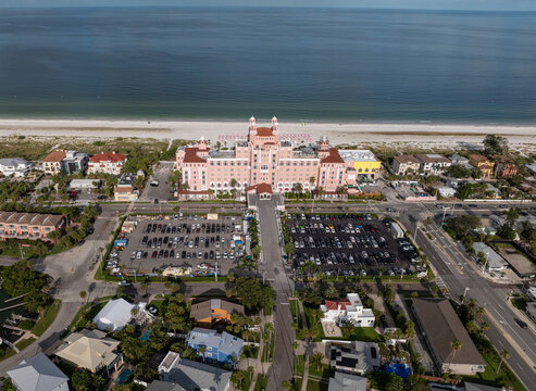 St. Pete Beach, Florida, United States - 12 July 2025: Aerial view of The Don CeSar, a historic pink hotel on the sandy coastline with parking lots and surrounding urban development.