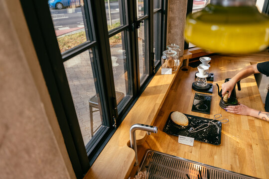 Modern Matcha Preparation at Specialty Coffee Bar with Sunlight and Urban Street View