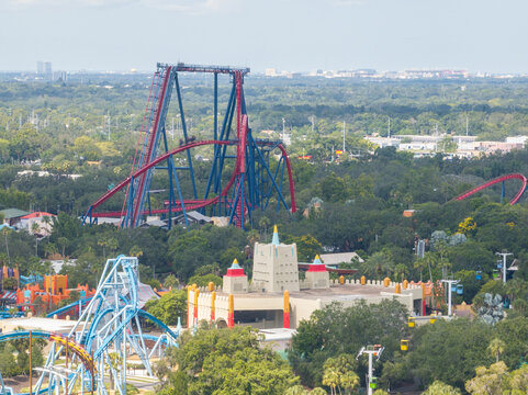 Tampa, United States - 10 July 2025: Aerial view of Busch Gardens Tampa Bay featuring the SheiKra roller coaster, lush green trees, and amusement park structures.