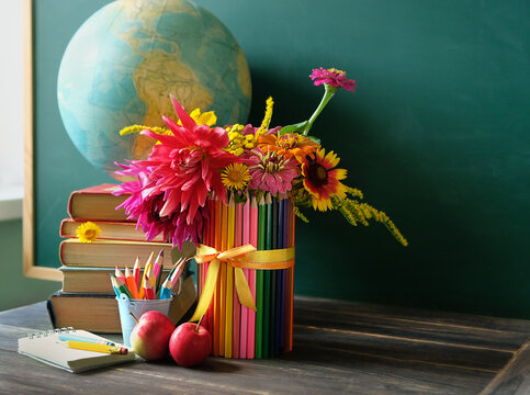 school stationery, apples, flowers, books, globe on table against chalkboard. Education, back to school, beginning of the school year, Teacher's day, Knowledge Day, 1 September concept. copy space