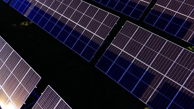 Aerial view of a large solar farm with photovoltaic panels arranged in rows, capturing renewable energy technology in a sustainable power plant