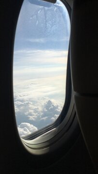 View of Clouds and Blue Sky Through an Airplane Window