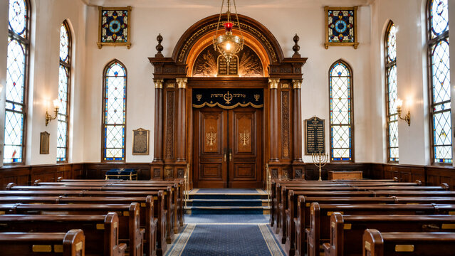 Synagogue interior with Torah ark and empty wooden pews
